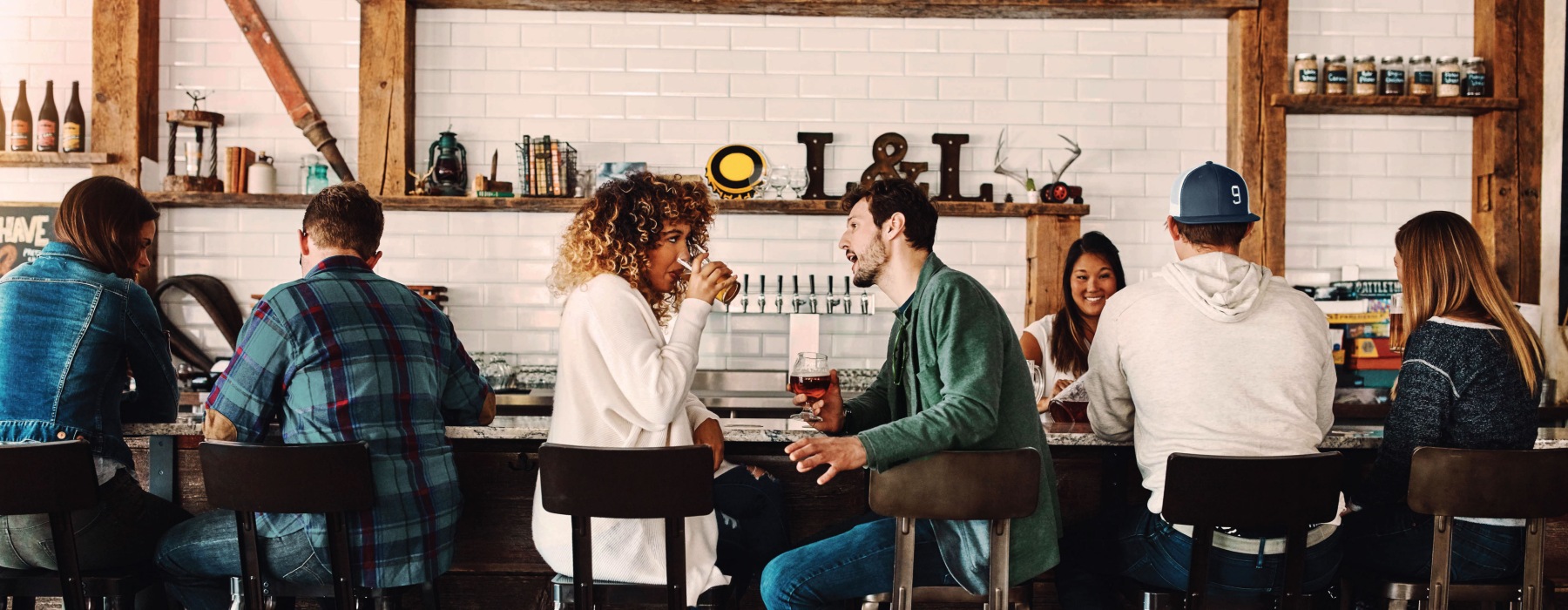 a group of people sitting at a bar drinking beer