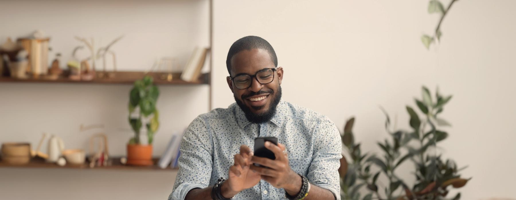 a man smiling and holding a phone