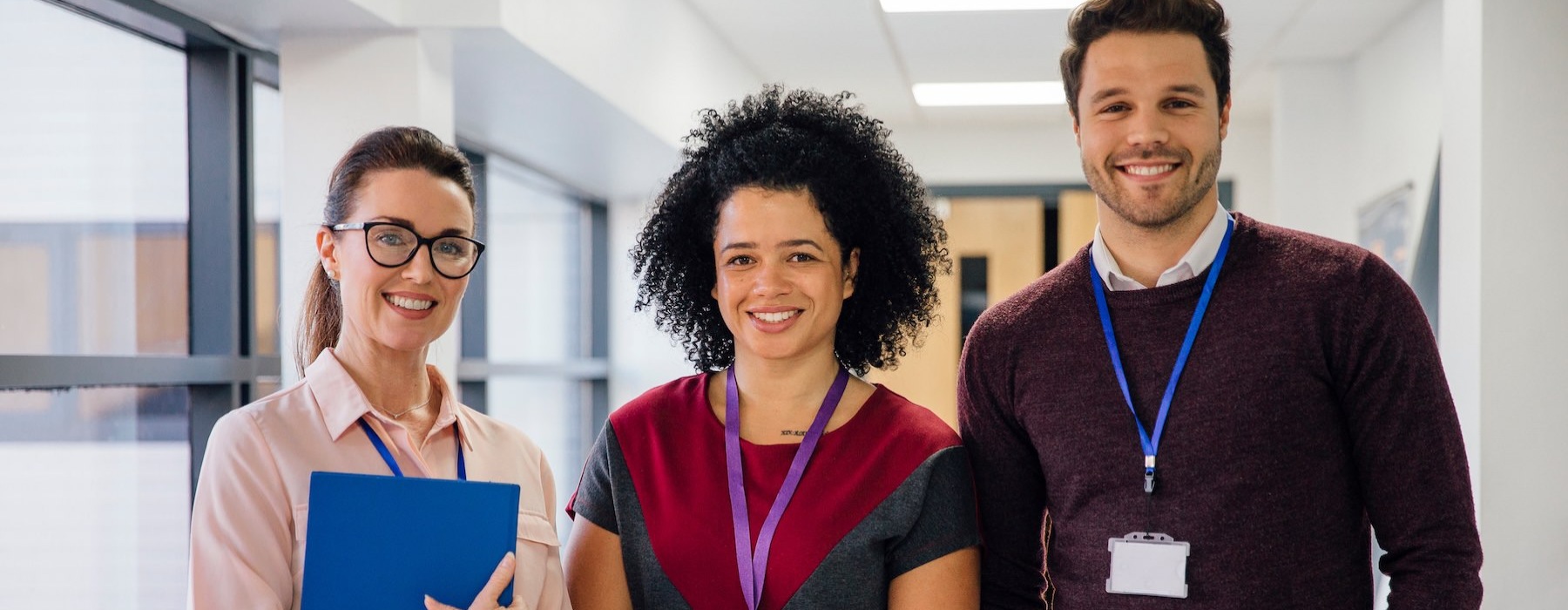 three co-workers standing and smiling